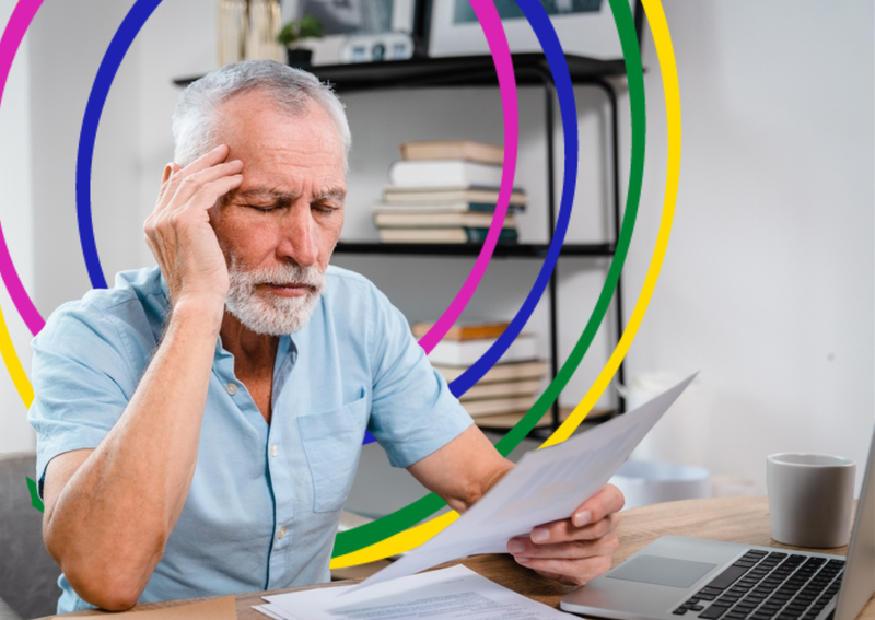 Stressed man reads paperwork at desk